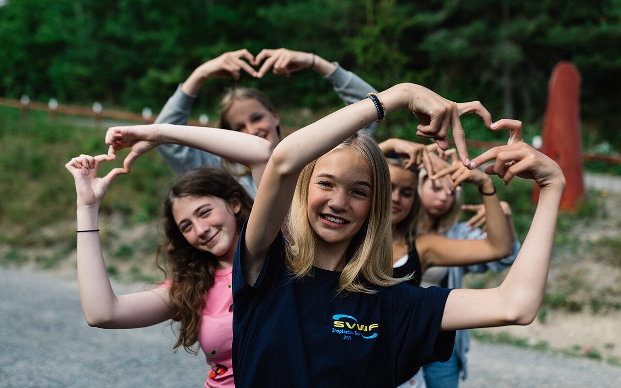 Ungdomar som gör "hjärt-tecken" med sina händer på kurs- och lägergården KFUM Brevik. Foto: KFUM Brevik.