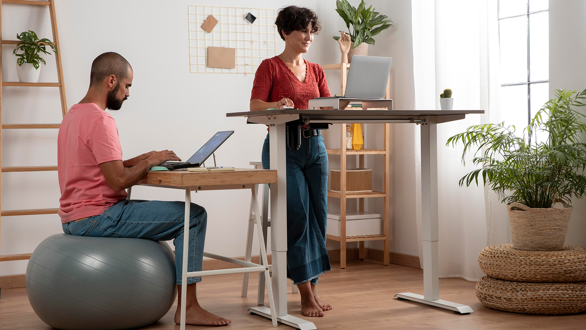 En person som jobbar sittandes på en pilatesboll och en som står upp och jobbar | Stå upp och jobba – rätt eller fel?