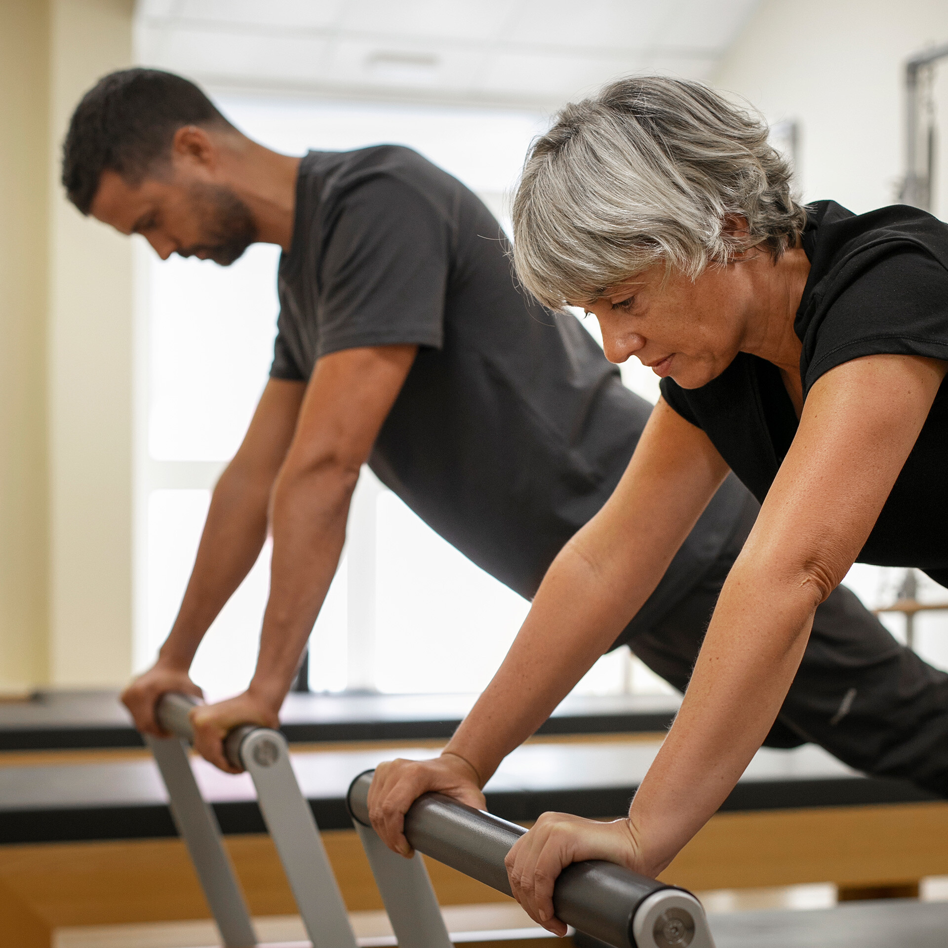 Två personer som tränar på en träningsmaskin.