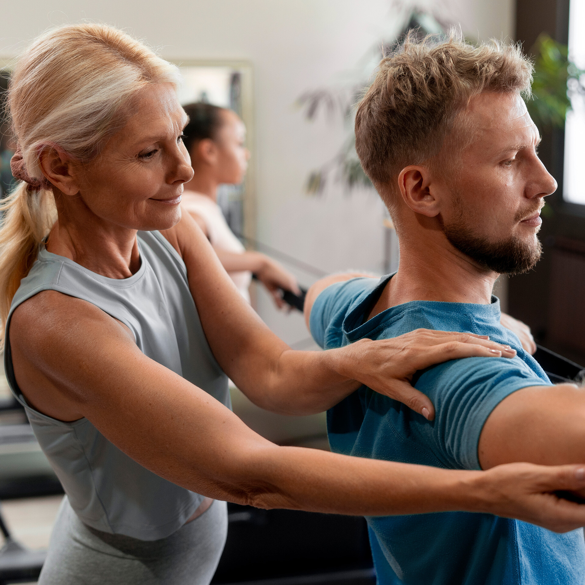 En träningsinstruktör hjälper en deltagare.